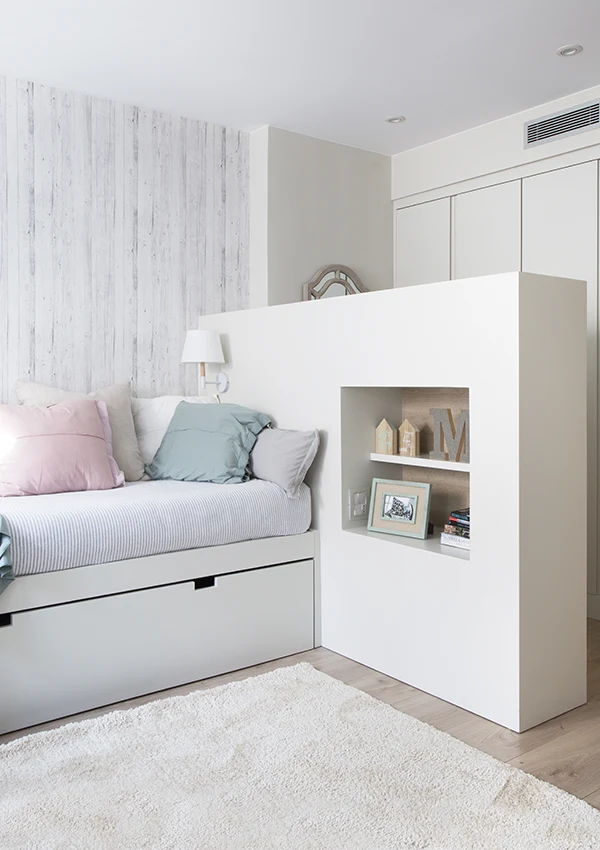 Dormitorio adolescente con pequeño espacio vestidor, separado por mobiliario de almacenamiento