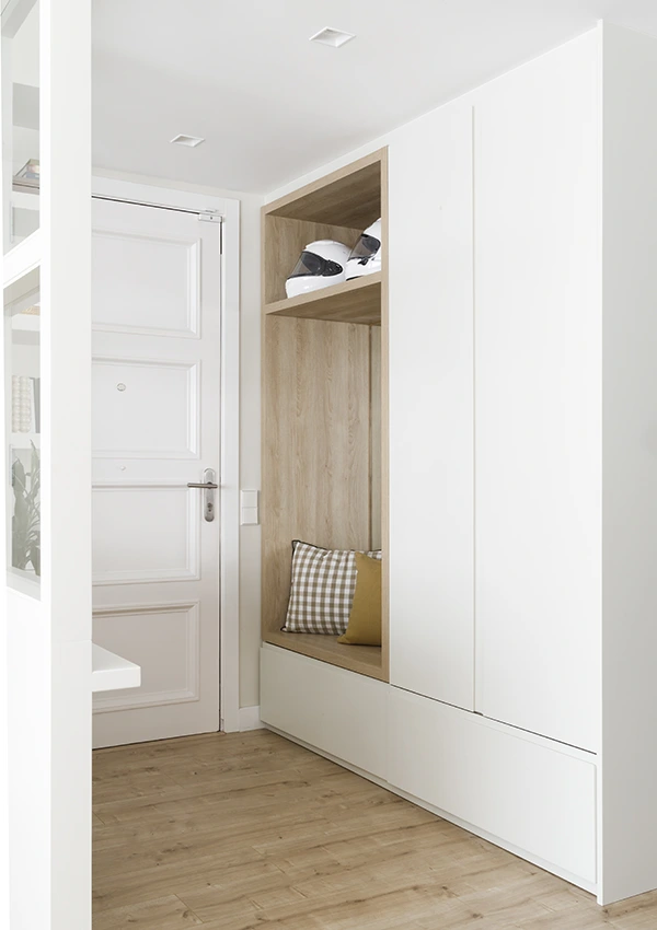 Recibidor en madera clara y blanco con doble mueble armario con banco integrado.
