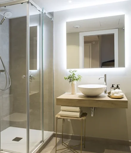 Plato de ducha, espejo y taburete en baño - Apartamentos Gala Placidia