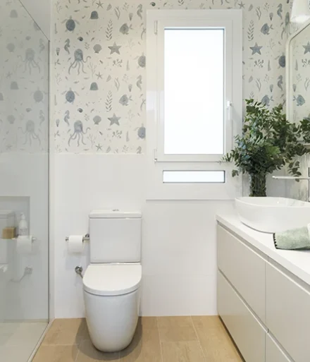 Baño infantil de base neutra con papel pintado en la zona superior - Proyecto Eixample