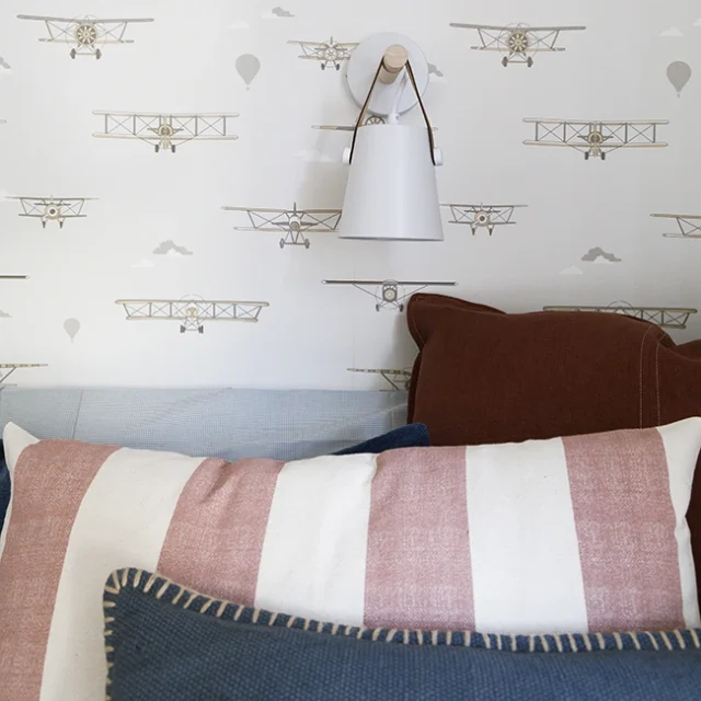 Lámpara colgante de color blanco sobre cama infantil.