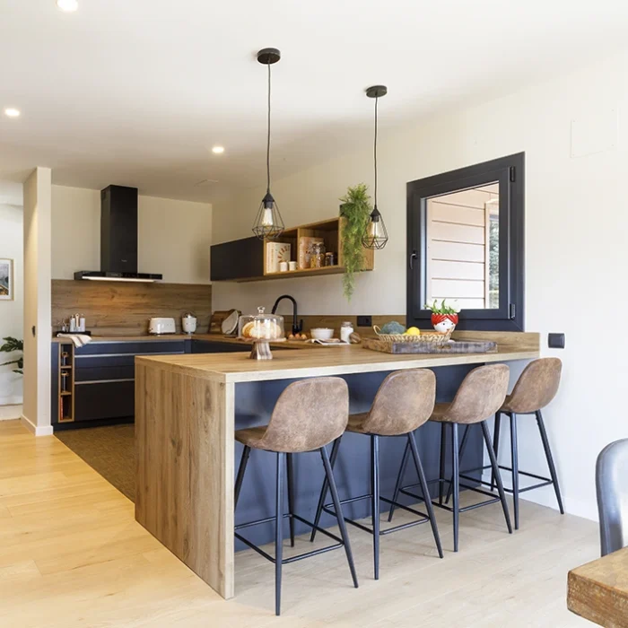 Cocina abierta con mueble de bar para desayunos.