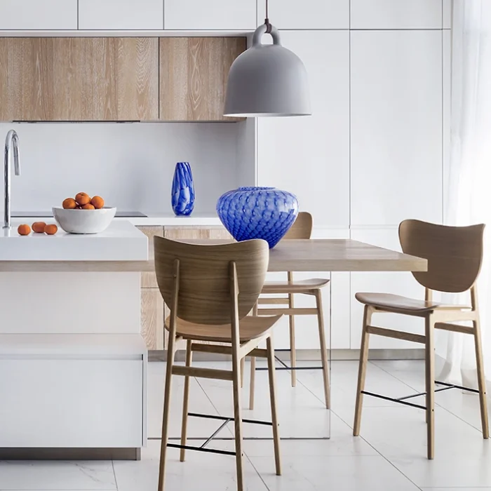 Cocina minimalista en tonos blancos y maderas claras.