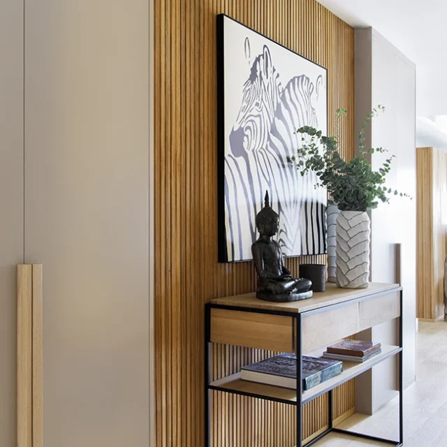 Decoración de plantas, figuras y libros en el recibidor - Proyecto Balmes