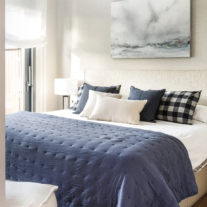 Dormitorio de matrimonio con paleta de colores crema y azul marino.