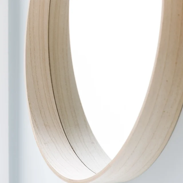 Espejo redondo de madera clara.