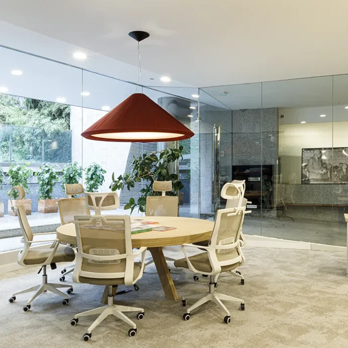 Mesa redonda para seis personas con lámpara de techo roja.