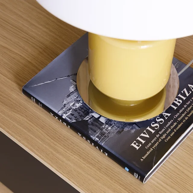 Lámpara amarilla sobre libro decorativo - Proyecto Balmes