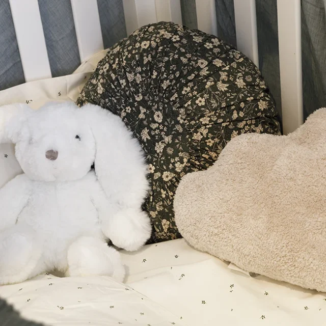 Peluches y cojines decorativos en cuna para bebé - Proyecto Eixample