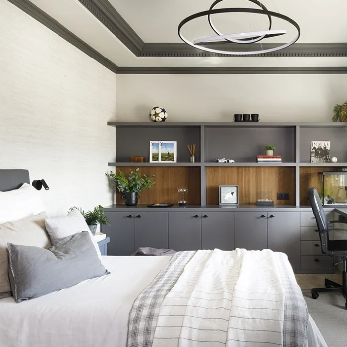 Habitación para niño con cama doble, escritorio y espacio de almacenamiento en tonos grises.