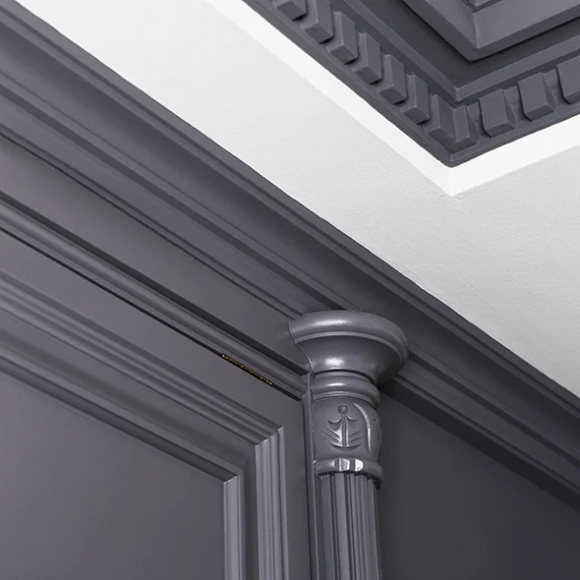 Pared de color gris oscuro con molduras.