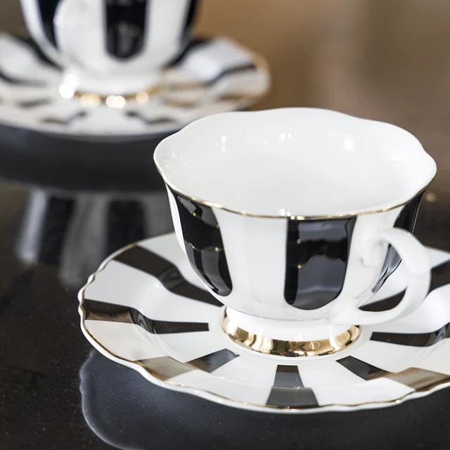 Tazas en colores blanco y negro con bordes dorados.