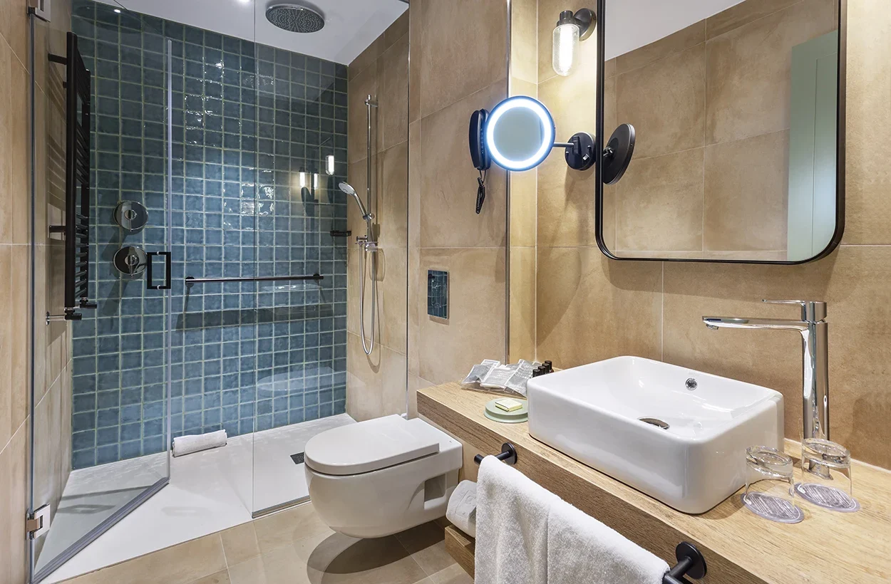 Pared acento de color azul y acabado diferente en baño de hotel.