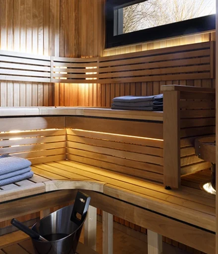 Sauna finlandesa con cubo y pala para subir la temperatura.