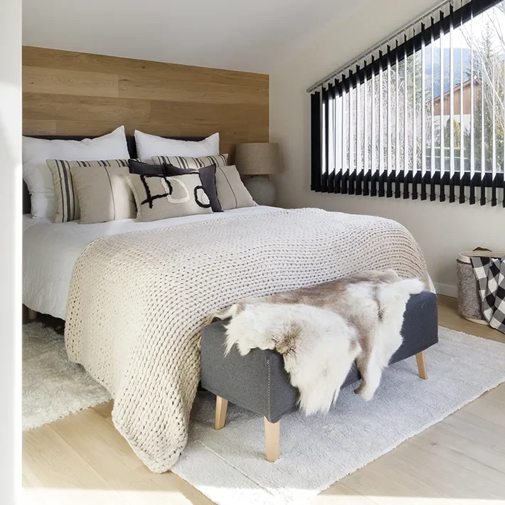 Suite luminosa con maderas claras, colores crema y cojines y banco en azul marino para crear contraste.