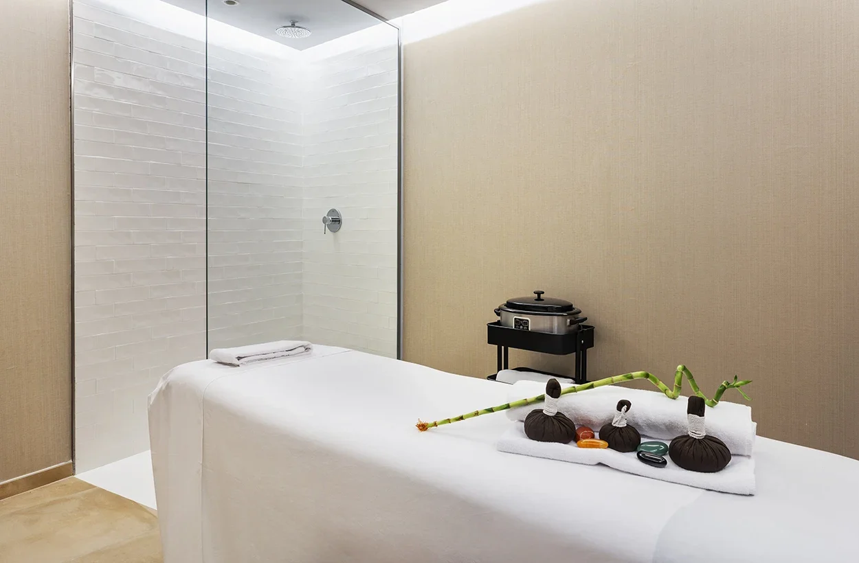 Spa con revestimiento textil de pared en tono beige.