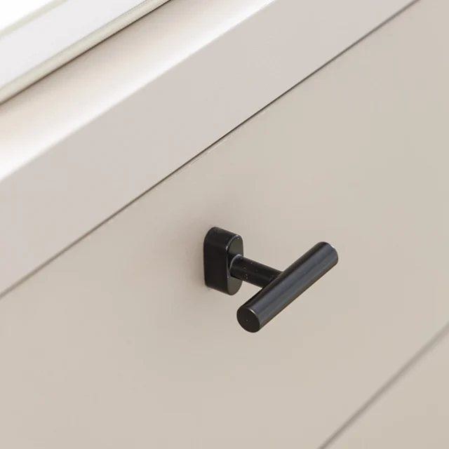 Tirador negro minimalista en cajón de escritorio.