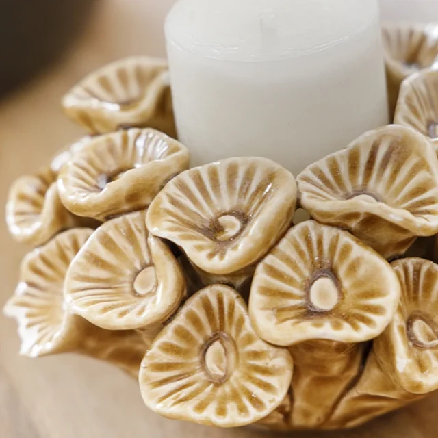 Porta velas decorativo con figuras de flores.