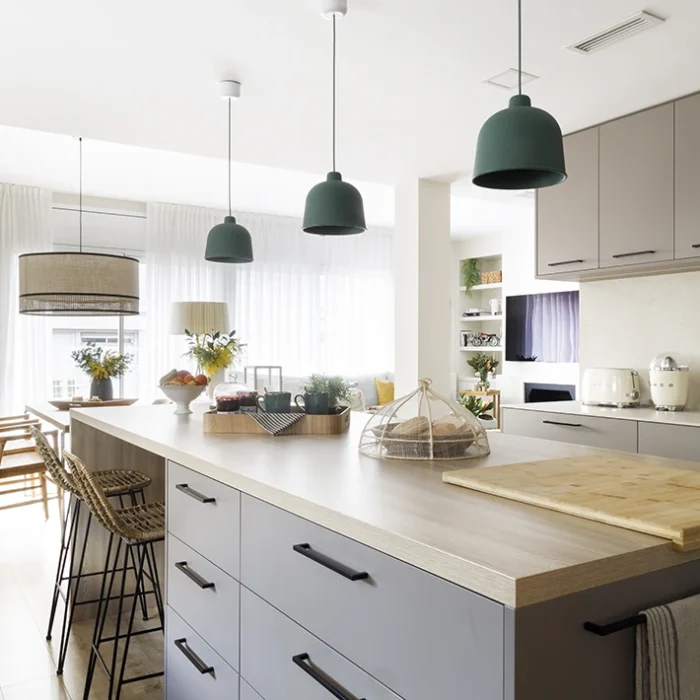 Isla de cocina con zona de bar en cocina abierta cerca del comedor.