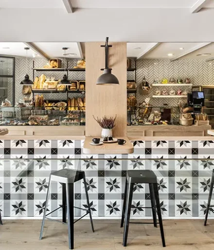 Espejos, taburetes y mesitas en el interior de la panadería La Farineta